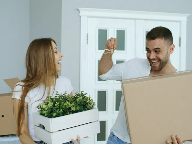 A couple moving boxes into a new home